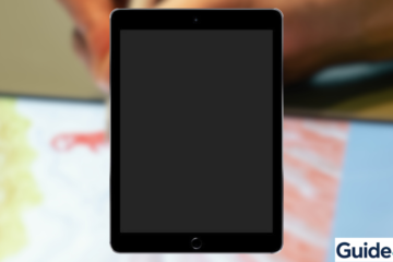 An iPad showing a black, unresponsive screen on a desk next to a MacBook and professional maintenance tools. The setup illustrates the steps to fix an iPad Black Screen of Death, including force restarting and using DFU recovery mode as taught by Guide4Mac