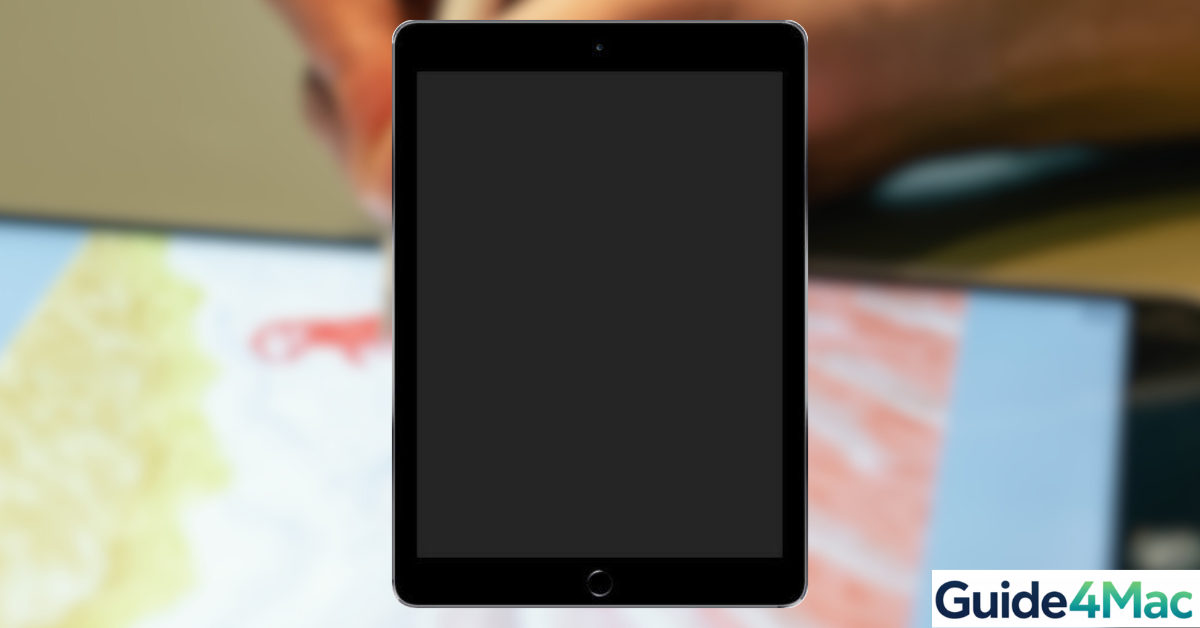 An iPad showing a black, unresponsive screen on a desk next to a MacBook and professional maintenance tools. The setup illustrates the steps to fix an iPad Black Screen of Death, including force restarting and using DFU recovery mode as taught by Guide4Mac