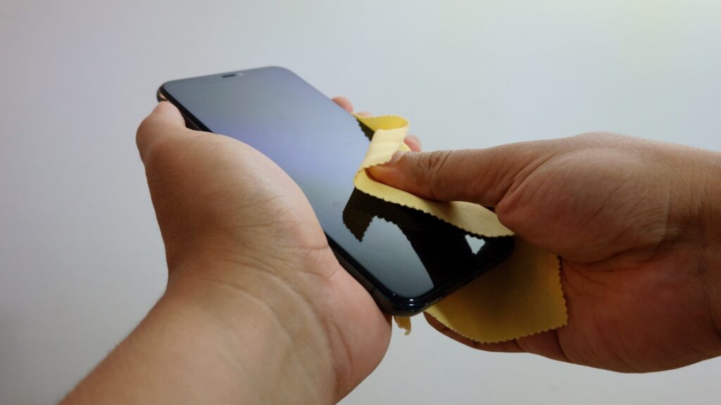 Cleaning an iPhone screen with microfiber cloth